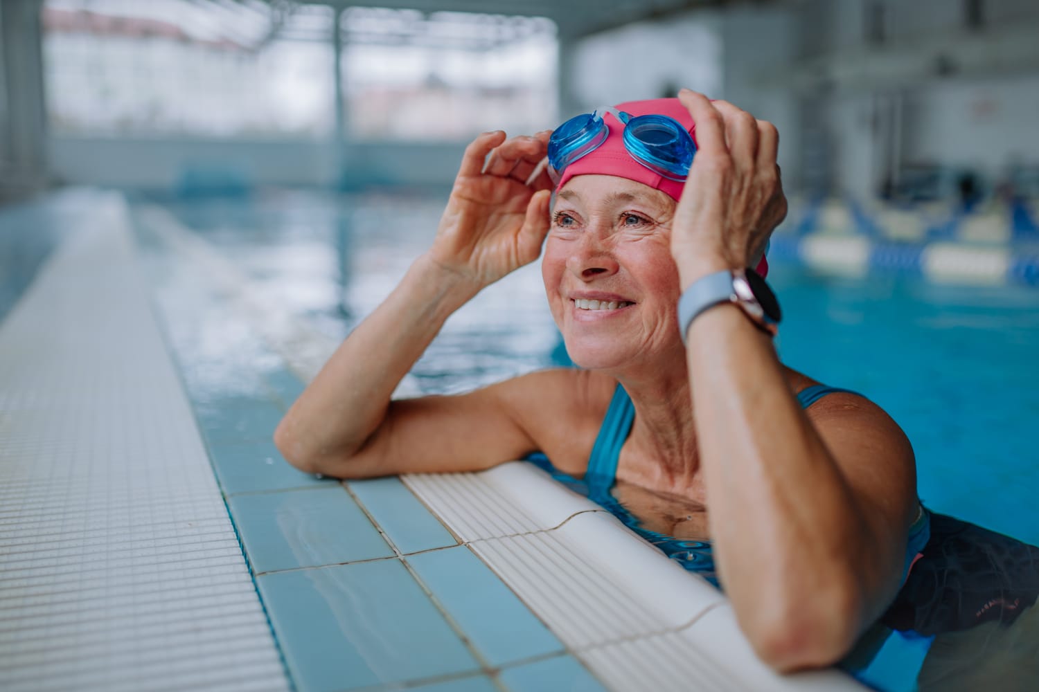 Glückliche ältere Frau am Rand eines Schwimmbads